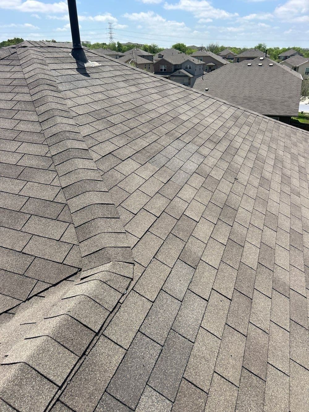 Detailed view of a residential roof with asphalt shingles, showcasing texture and alignment.