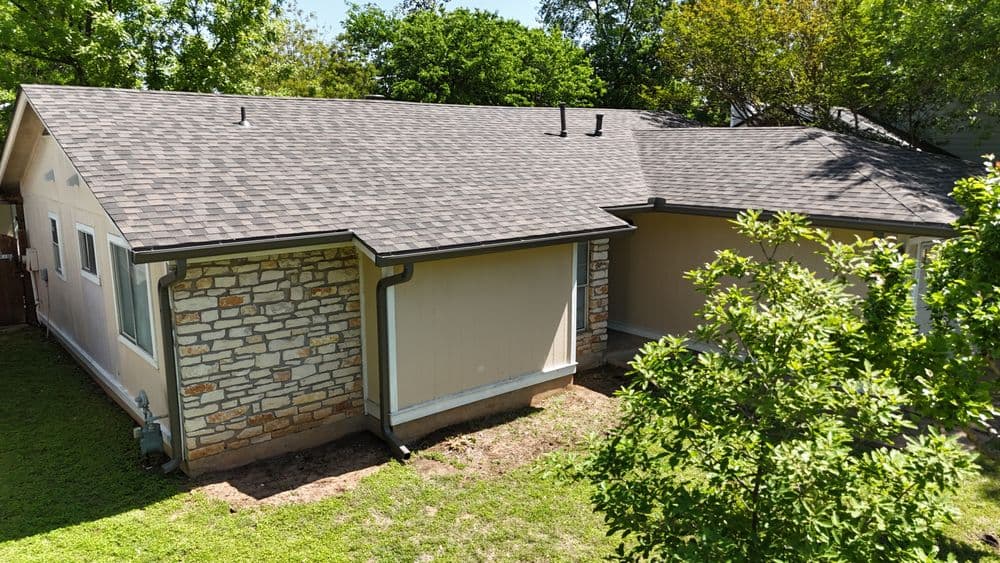 Exterior view of a home featuring a stone and siding facade with a landscaped yard.