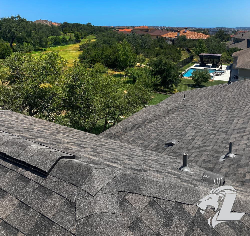 Overview of a residential roof with shingles, featuring a scenic view of green landscape and pool.